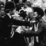 Homem negro diante de policial branco durante as revoltas raciais de Notting Hill. Fonte: Popular Resistence