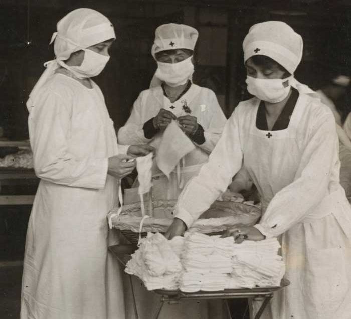 Trabalhadoras da Cruz Vermelha de Boston, Massachusetts, removendo pacotes de máscaras para soldados americanos, 1918.